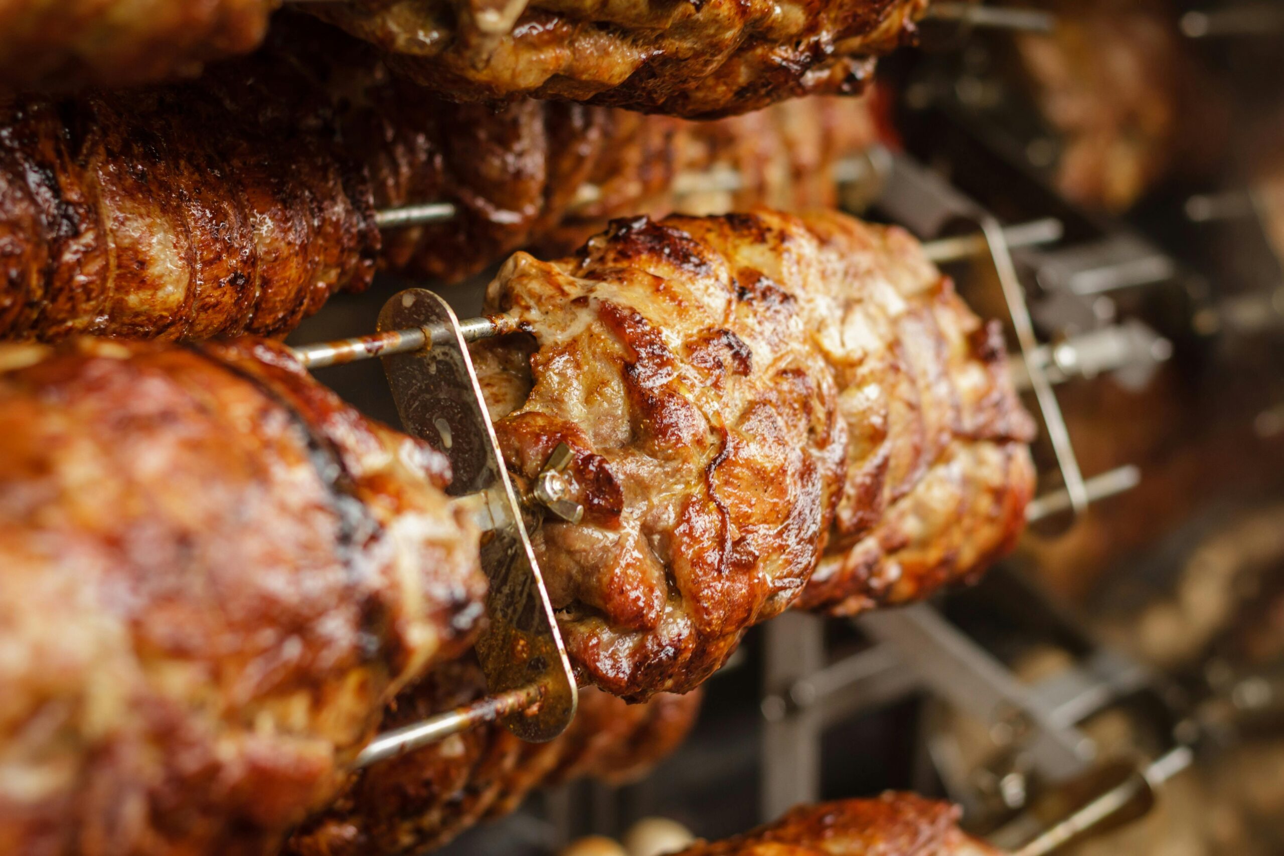 Close-up of juicy and perfectly grilled rotisserie pork, ideal for barbecue lovers.